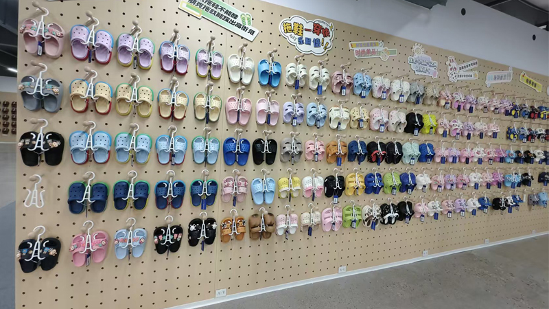 alt="Wide selection of colorful EVA slippers displayed on wall showing popularity of EVA in slipper manufacturing"