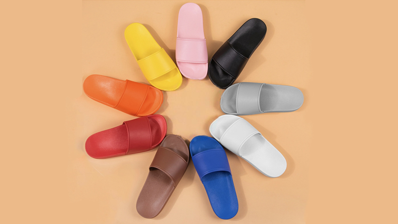 alt="Colorful PVC slippers arranged in multiple styles and colors for budget-friendly wholesale programs"