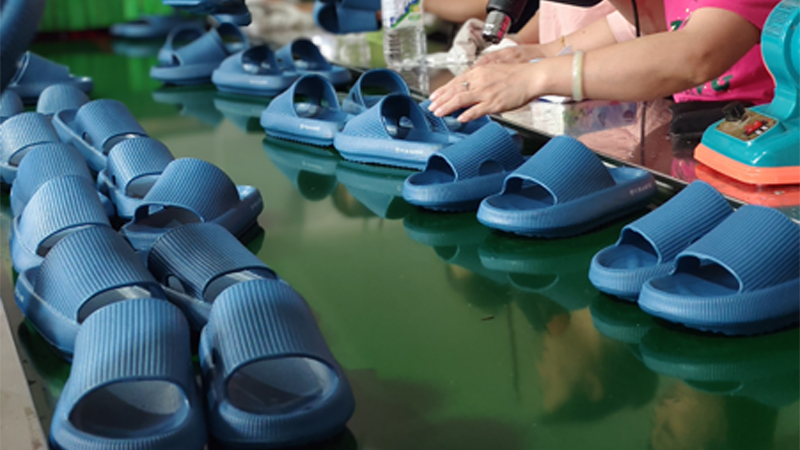 alt="EVA slippers on a production line showing efficient bulk manufacturing for wholesale orders"
