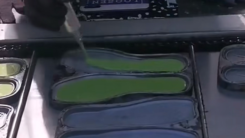 alt="Rubber outsole molding process for slipper manufacturing showing rubber material formed in sole molds"