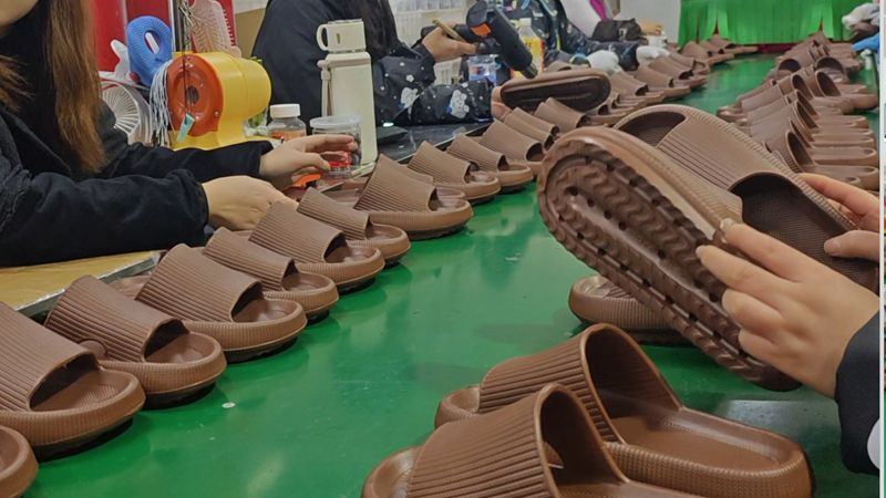 alt="Slipper factory production line with molded slippers being assembled and inspected for bulk OEM orders"