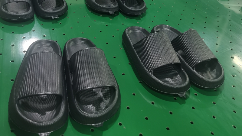 alt="Finished EVA and PVC slippers on a factory worktable showing quality inspection before packing"